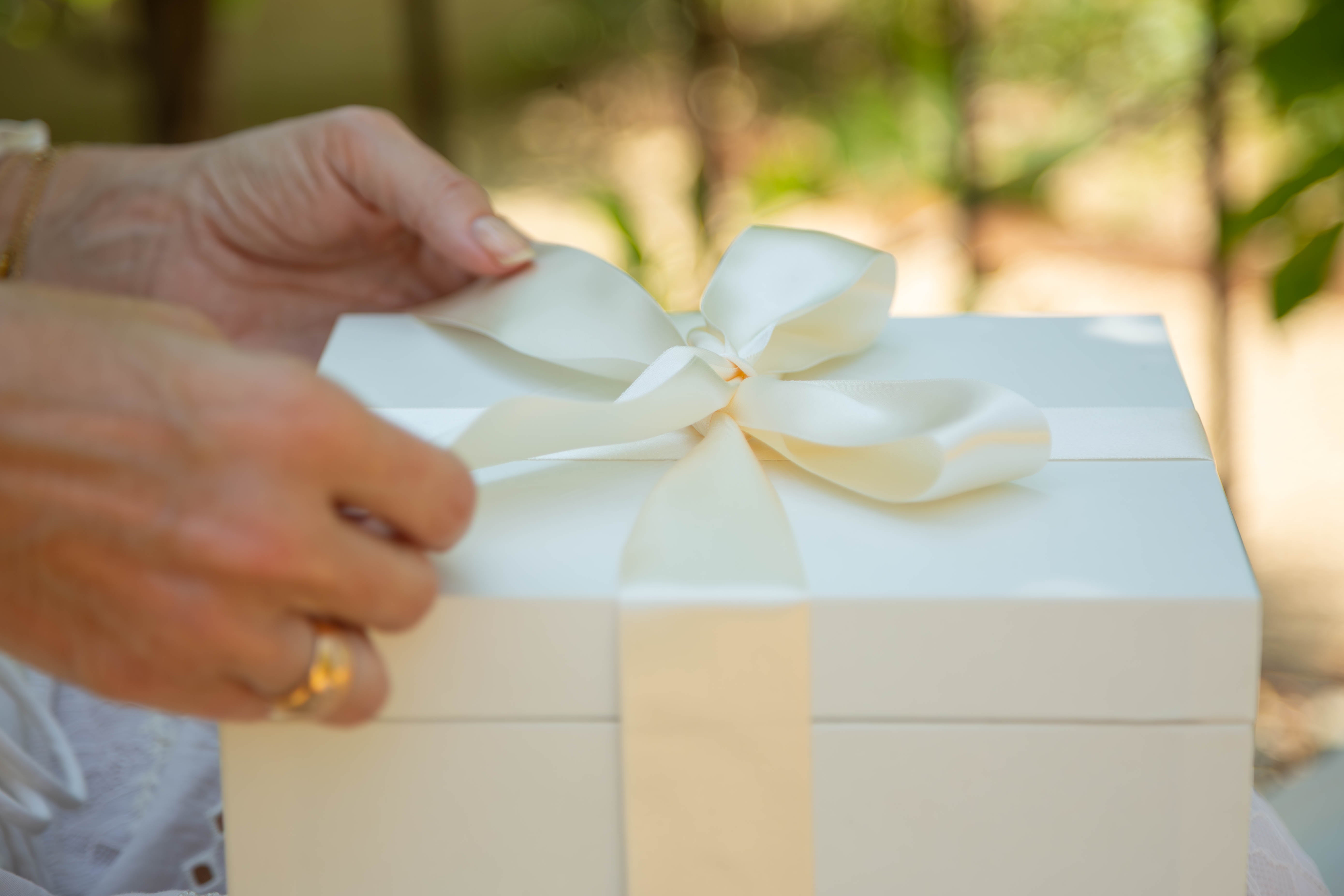 Mains ouvrant un cadeau de la maison Franc 1884