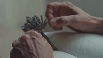 Vidéo montrant une artisane en train de tresser minutieusement des boules de lavande avec des rubans, illustrant le savoir-faire de l'artisanat français.